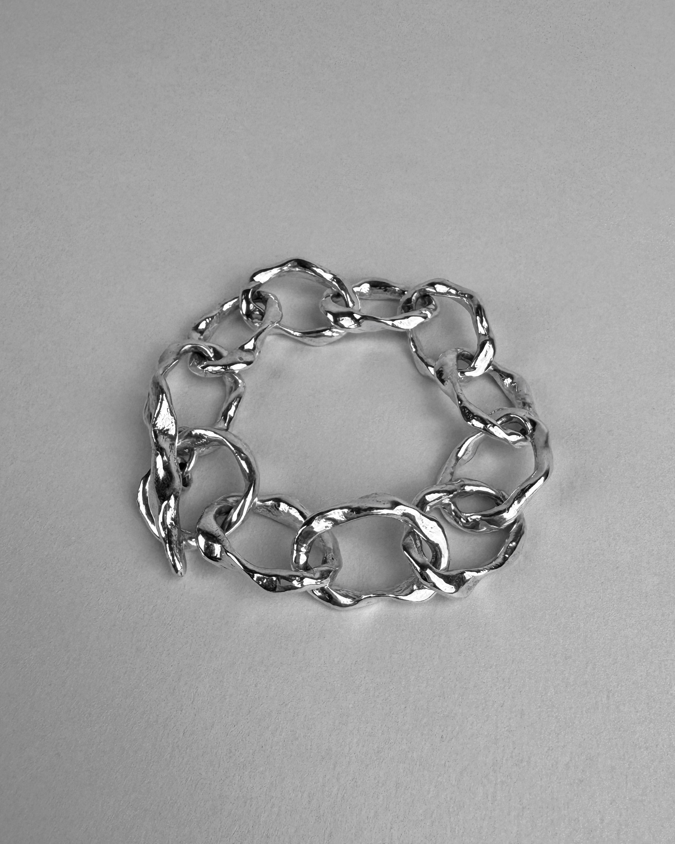 Silver chain bracelet on a gray background